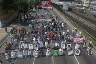 Avance del contingente conformado por activistas y familiares de los nomalistas de Ayotzinapa sobre Avenida Tlalpan rumbo al Zócalo capitalino. Durante el avance, algunos asistentes arrancaban propaganda electoral. Foto: Pablo Ramos