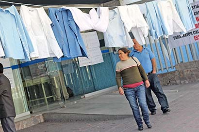 Los empleados mantienen colgadas batas en la entrada del nosocomio, a manera de protesta ■ FOTO: ANDRÉS SÁNCHEZ