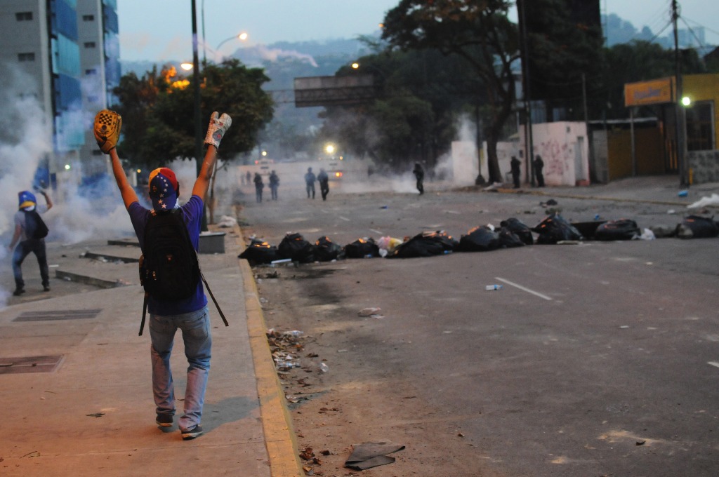 Un manifestante participa durante un enfrentamiento con la Policía Nacional Bolivariana, en Altamira, en Caracas, la víspera. Foto Xinhua