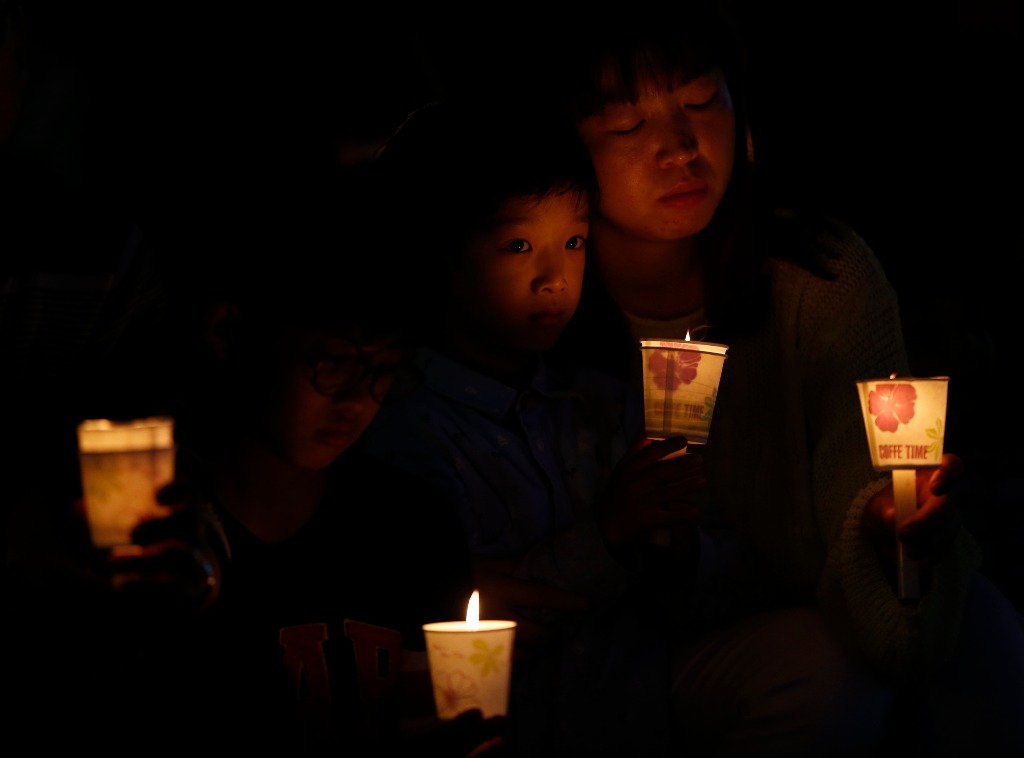 Familiares y amigos participan en la vigilia en memoria de las víctimas del naufragio en Corea del Sur. Foto Reuters