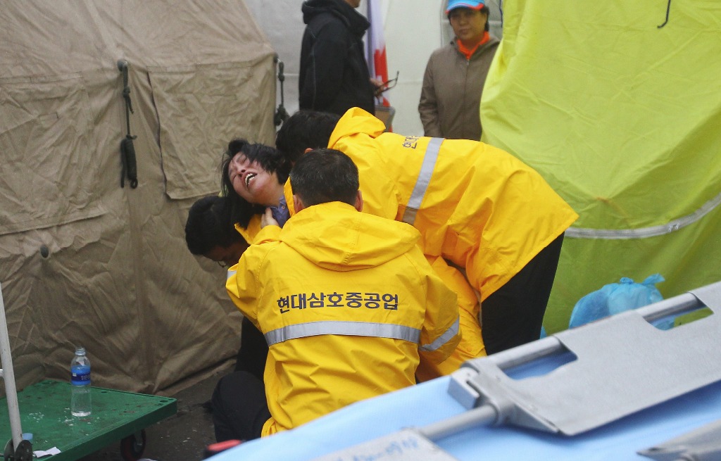 Familiares de pasajeros desaparecidos a bordo del ferry 'Sewol' que naufragó en Corea del Sur reaccionan mientras esperan noticias sobre el rescate, en Jingo. Foto Xinhua