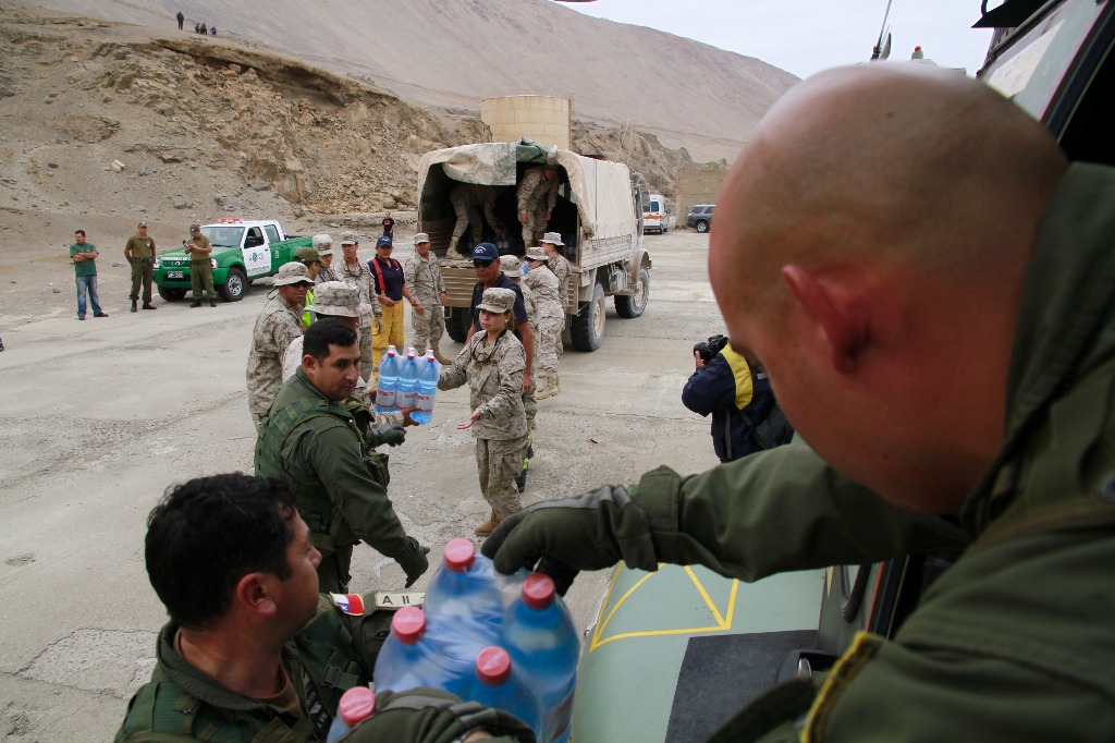 Militares descargan alimentos en la caleta de Pisagua, al norte de Chile. Foto Xinhua