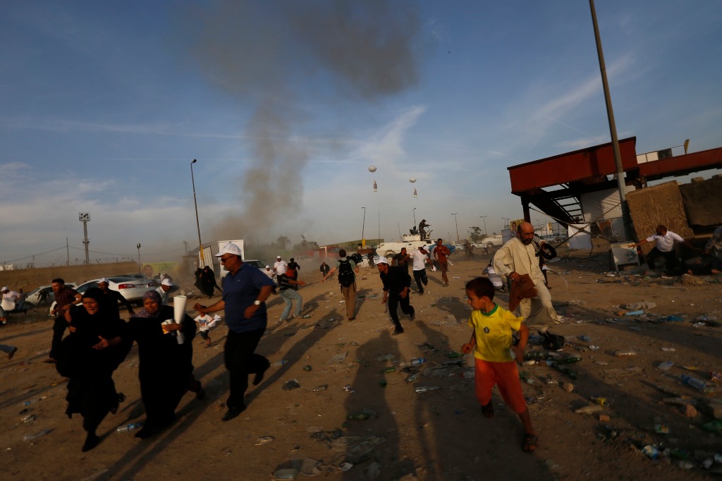 Asistentes a un mitin político huyen tras la explosión de un coche bomba en Bagdad. Foto Reuters