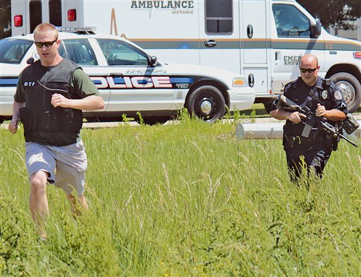 El detective antinarcóticos Josh Talbott (izquierda) y el patrullero Duane Busby cruzan un campo cerca de un camino al acudir a un aviso sobre un ataque a tiros en Jonesboro, Arkansas. Foto Ap