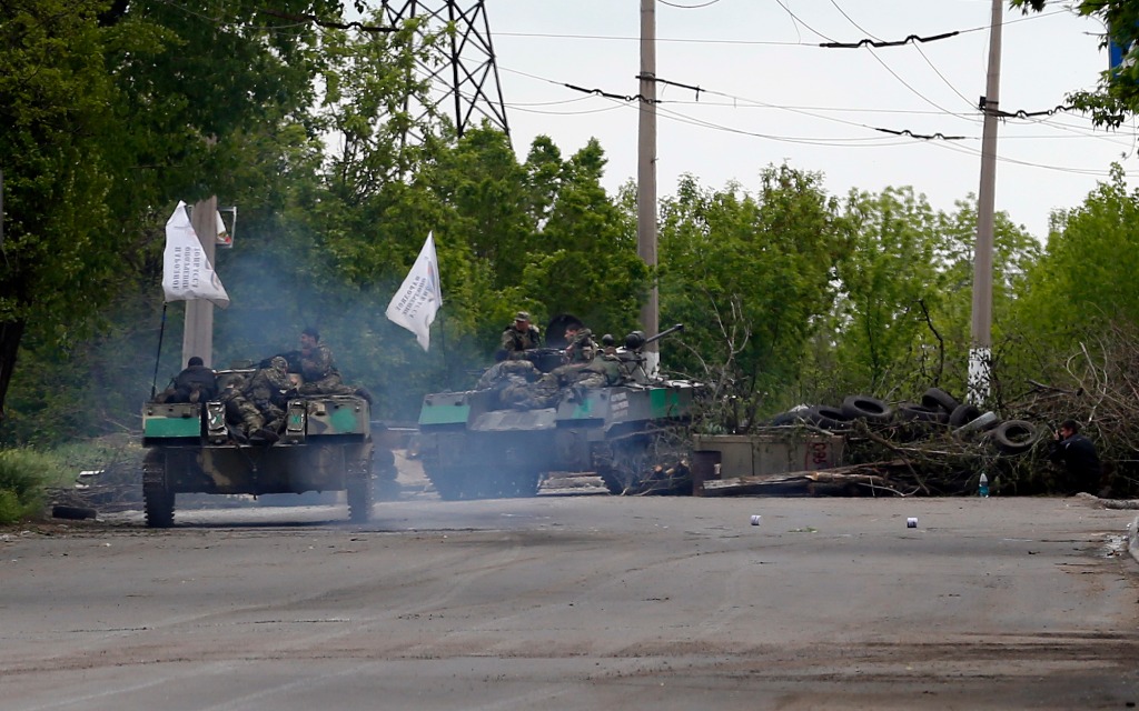 Simpatizantes rusos armados pasan sobre una barricada en ruta hacia la ciudad de Slovyansk, Ucrania. Foto Ap