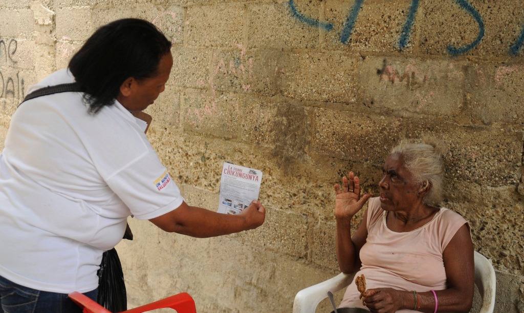 Una trabajadora de salud reparte folletos en República Dominicana. Foto Reuters