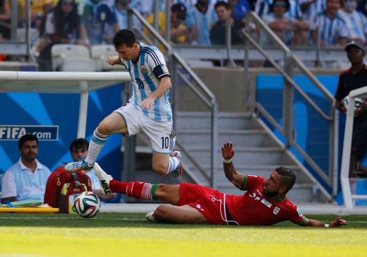 Lionel Messi disputa el balón a iraní Ashkan Dejagah.Reuters