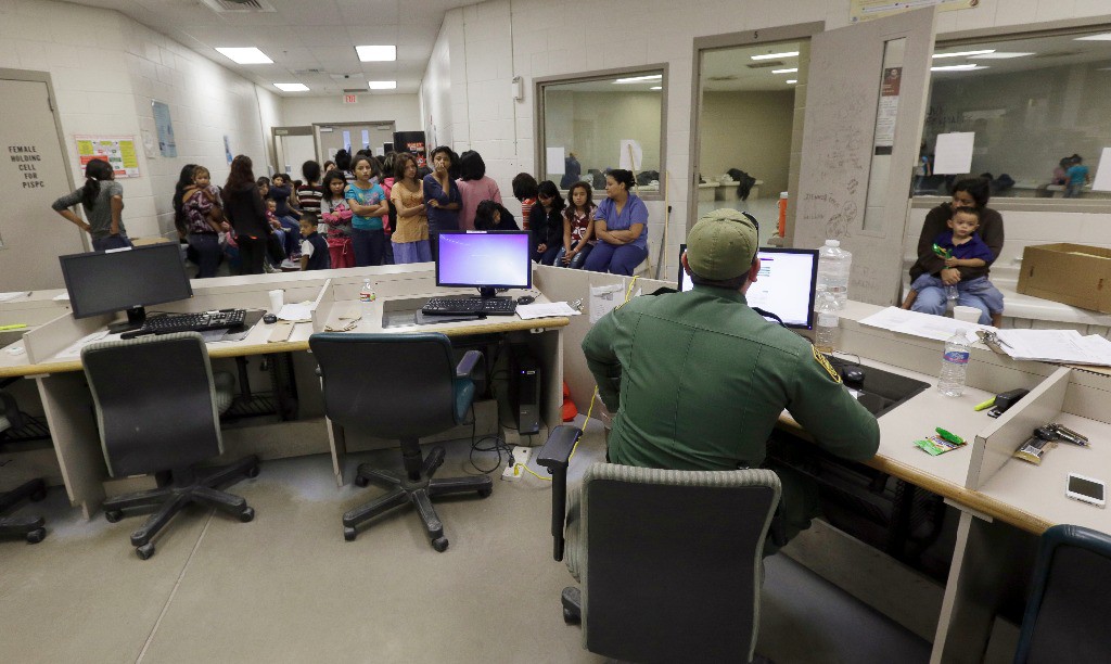 Agentes de Aduanas y Protección Fronteriza de EU trabajan en un centro de procesamiento en Brownsville, Texas. Imagen del 18 de junio de 2014. Foto Ap