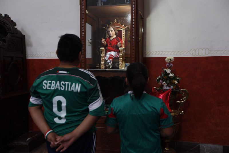 Dos menores asisten al templo de Tacubaya a pedirle al niño de los milagros el triunfo de la selección mexicana. Foto: La Jornada