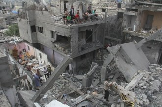 Rescatistas palestinos inspeccionan un edificio destruido por un ataque aéreo israelí que cobró la vida de ocho personas en la ciudad de Khan Yunis, este jueves. Foto Xinhua
