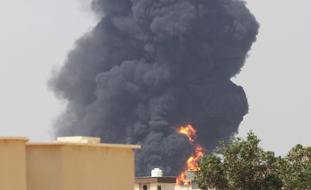 Una densa columna de humo emana desde el depósito de petróleo Brega, en Trípoli. Foto Xinhua