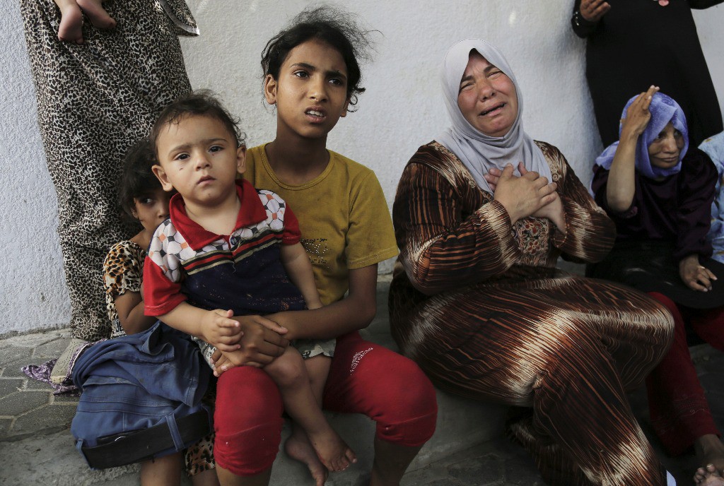 Refugiados palestinos lloran después del ataque contra una escuela de la ONU en Gaza, este jueves. Foto Ap