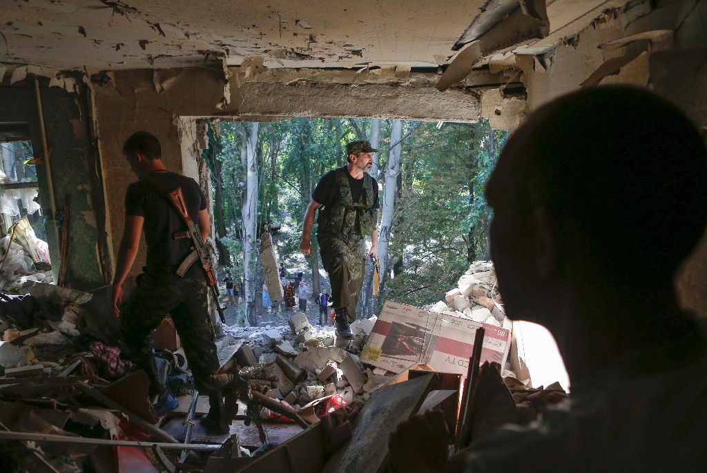 Separatistas pro rusos buscan entre los escombros posibles víctimas tras el ataque de fuerzas ucranias en Donetsk. Foto Reuters