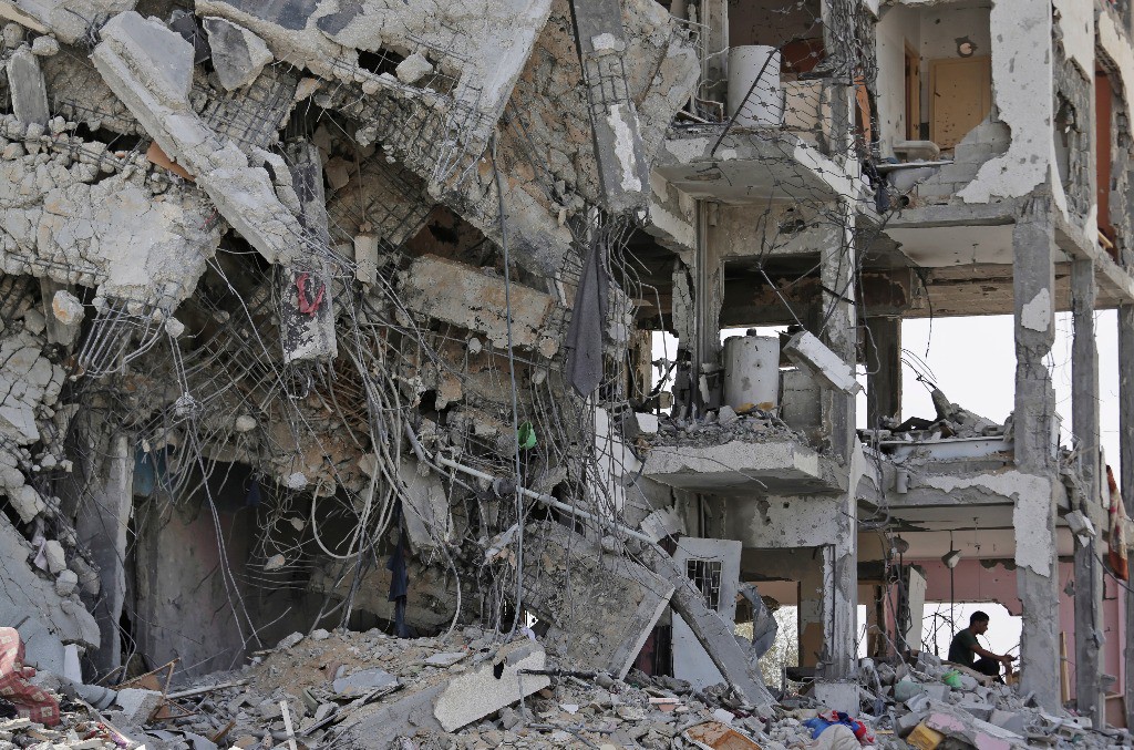 Un palestino observa los restos de un edificio destruido por los bombardeos israelíes en Gaza. Foto Ap