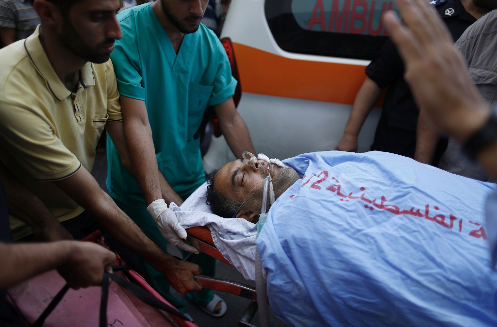 El fotógrafo Hatem Mussa, quien resultó herido tras estallar un artefacto cuando expertos intentaban desactivarlo, es trasladado a un hospital en Gaza, este martes. Foto Reuters