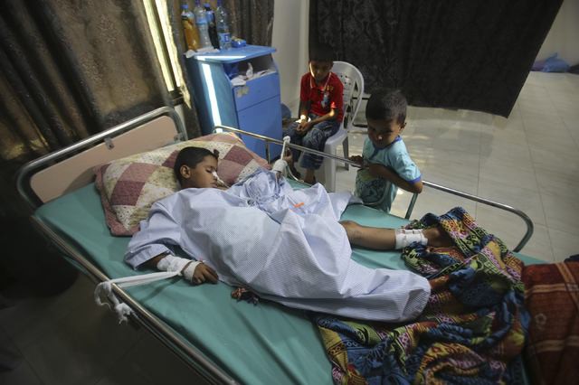 Un menor herido palestino es cuidado por otros niños en un hospital de rehabilitación de Gaza. Foto Reuters