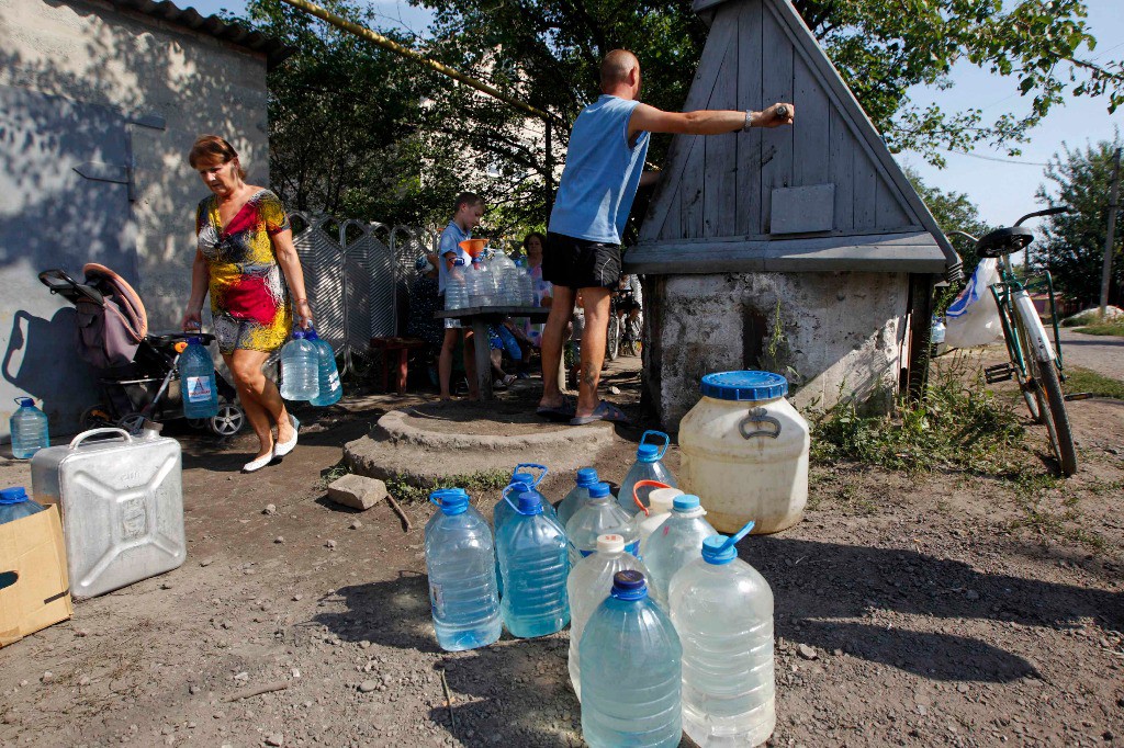 Ucranios recolectan agua en la región de Donietsk este viernes. Foto Reuters