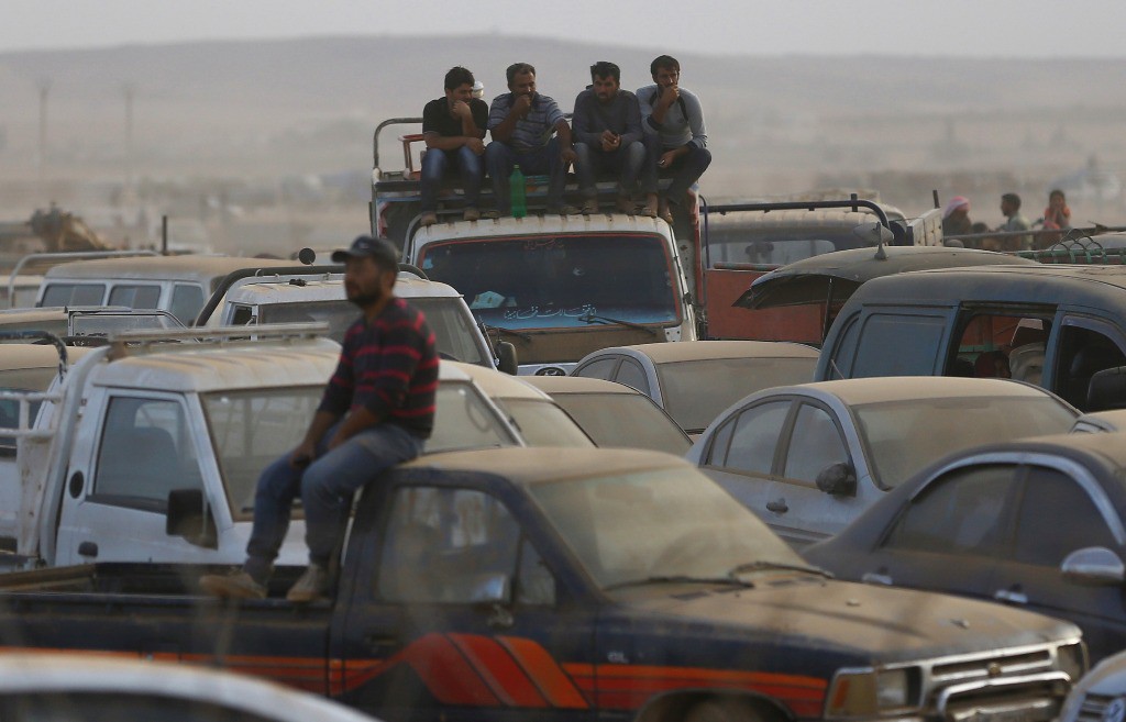Refugiados kurdos sirios esperan para cruzar a Turquía. Foto Reuters