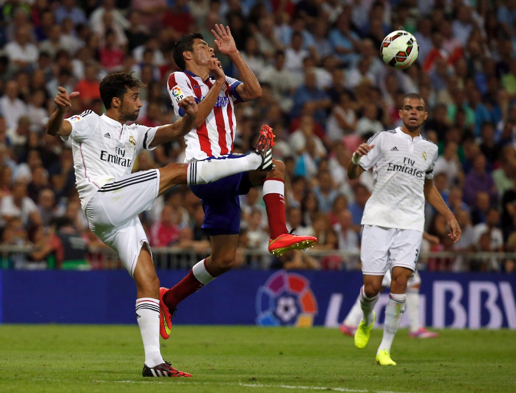 Alvaro Arbeloa, del Real Madrid, y Raúl Jiménez, del Atlético, disputan el control del balón en el derbi de la capital española en el Santiago Bernabéu. Foto Reuters