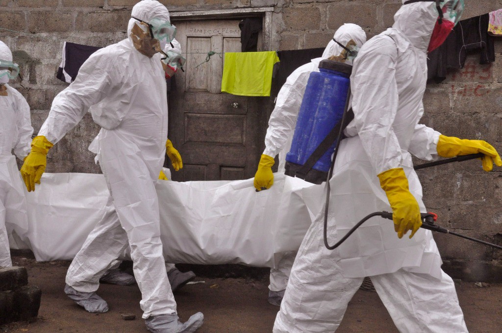 Trabajadores de salud llevan el cuerpo de una mujer que sospechan murió por el virus del ébola, en Monrovia, Liberia, este miércoles. Foto Ap