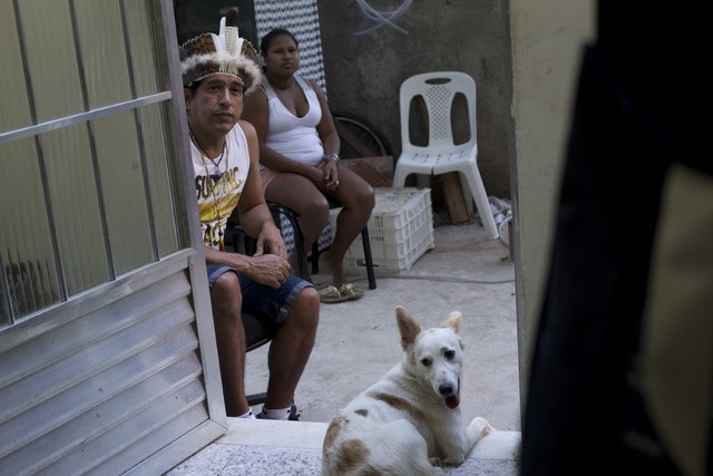 El indígena Afonso Xamakiri, a la izquierda, viste un penacho mientras observa un partido de futbol en la favela Mare de Río de Janeiro, en imagen del 24 de agosto. Foto Ap