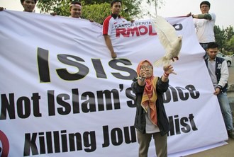 Una mujer musulmana libera una paloma en símbolo de paz, durante una manifestación contra el Estado Islámico, en Yakarta, Indonesia. Foto Ap
