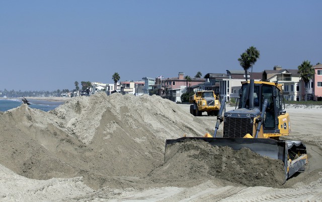 Trabajadores construyen una barricada de arena en Long Beach California, para proteger las casas ante la llegada del huracán 'Norbert'. Foto Ap