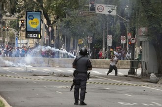 Un policía dispersa con gas lacrimógeno a los “sin techo” que ocupaban un hotel de Sao Paulo. Foto Ap
