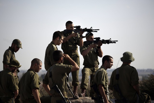 Soldados israelíes apuntan este lunes hacia Gaza, antes de iniciar ejercicios de entrenamiento cerca de la frontera de Israel con la franja. Foto Ap