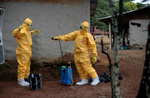 Dos inspectores de salubridad en Liberia se someten a limpieza antes de quitarse los trajes. Foto Ap