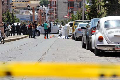 Peritos de la Procuraduría, durante el análisis de pruebas en el asesinato de una mujer en la avenida López Velarde. Imagen de septiembre de 2012 ■ FOTO: LA JORNADA ZACATECAS