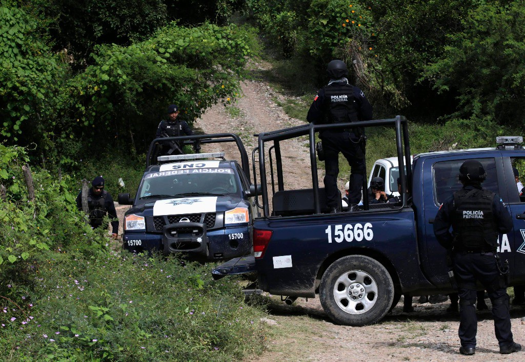 Policías Federales vigilan en una zona cercana a las fosas clandestinas, en Pueblo Viejo, Guerrero. Foto Reuters