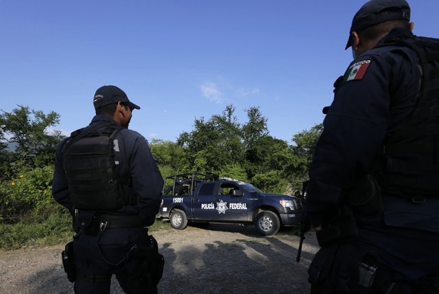 Policías federales vigilan un camino cerca las de las fosas clandestinas en Pueblo Viejo, en Guerrero. Foto Reuters