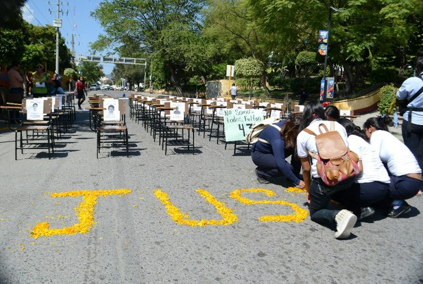 Bloqueo en la avenida Juárez, de Chilpancingo, Guerrero, donde estudiantes colocaron antier una ofrenda floral y retratos de los 43 estudiantes desaparecidos en igual número de butacas. Foto Cuartoscuro