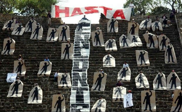 Activistas de la organización Comuna tomaron simbólicamente una pirámide de Monte Albán, Oaxaca; en la imagen sostienen siluetas que representan a los 43 normalistas desaparecidos en Iguala. Foto Reuters/Archivo