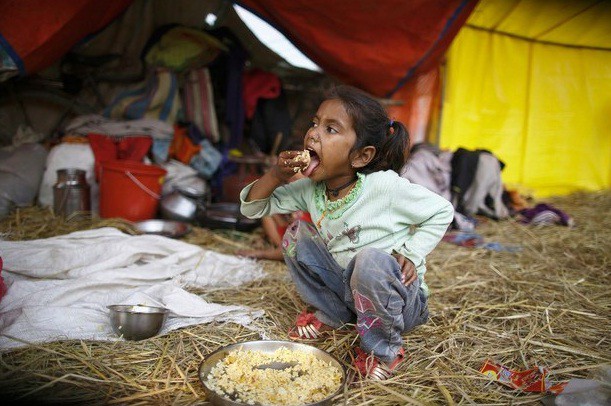 Una niña come su almuerzo dentro de una tienda de campaña durante el festival 