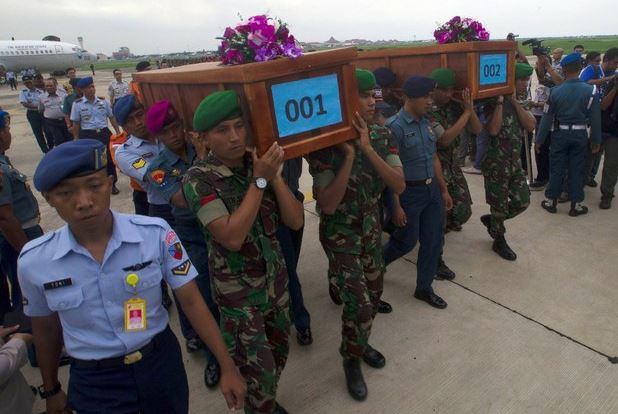 Dos cuerpos, en ataúdes coronados con flores y marcados 001 y 002, llegaron en un avión de la fuerza aérea a Surabaya. Foto Reuters