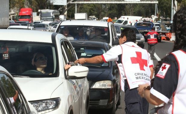Voluntarios de Cruz Roja reparten volantes informativos en la caseta de la carretera México-Cuernavaca. Foto María Luisa Severiano
