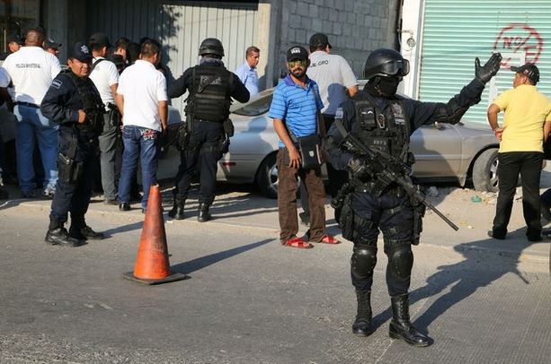 Un elemento de la Policía Federal dirige el tránsito frente a un vehículo donde se encontraron dos cuerpos en Acapulco, Guerrero, en imagen del 18 de diciembre pasado. Foto Xinhua