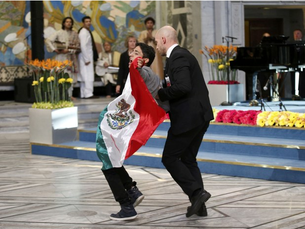 Un joven con una bandera mexicana intentó llegar hasta Malala, minutos después de que la joven paquistaní recibiera su premio, pero fue detenido por agentes de seguridad. Foto Reuters