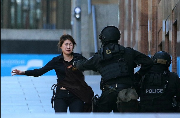 Una rehén escapa de un café de Sidney y corre hacia la policía para resguardarse, en imagen de ayer. Foto Ap