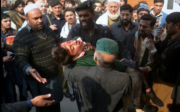 Guardias de seguridad llevan al hospital a estudiantes que resultaron heridos en el ataque talibán contra una escuela. Foto: AP
