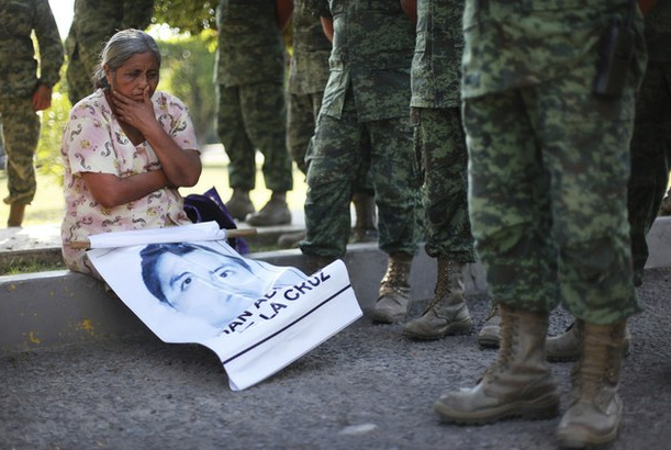 La madre de Adan Abarajan, uno de los 43 estudiantes desaparecidos de Ayotzinapa, junto a soldados frente a la entrada del 27 Batallón de Infantería, en Iguala, Guerrero, en imagen de ayer. Foto Ap
