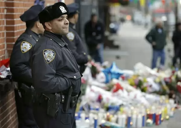 Oficiales de policía de Nueva York, junto al memorial dedicado a los dos oficiales asesinados el sábado pasado. Foto Ap