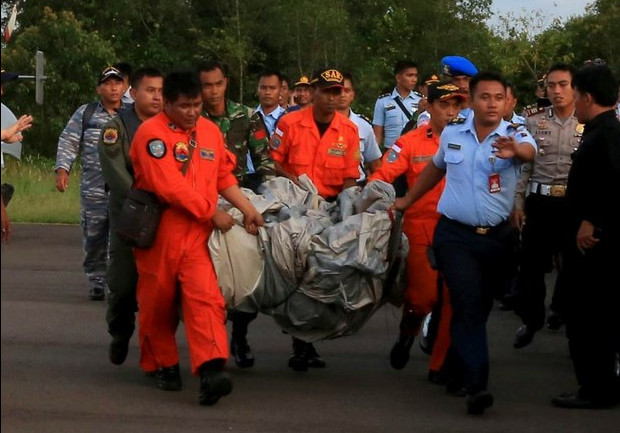 Personal del equipo de búsqueda y rescate transportan restos del avión de Airasia hallados hoy a unos 16 kilómetros de las últimas coordenadas conocidas del aparato. Foto Reuters