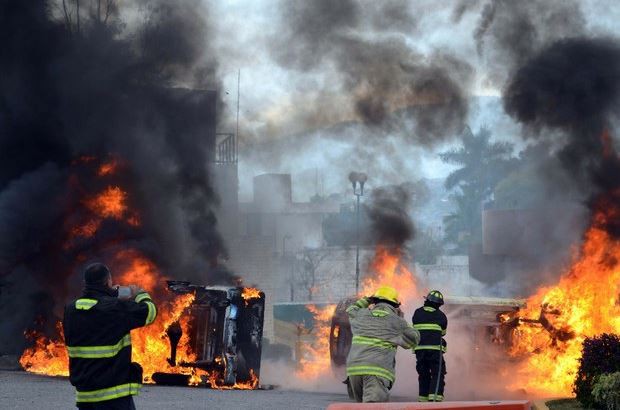 Autos incendiados durante los enfrentamientos este domingo. Foto Ap