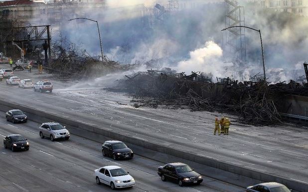 Bomberos de Los Ángeles observan los restos del edificio residencial en construcción después del incendio que lo consumió, en la carretera interestatal 110, cerca del centro de la ciudad. Foto AP