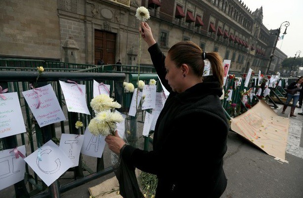 Un grupo de personas colocó cartas, flores y fotografías para recordar a los normalistas desaparecidos de Ayotzinapa ante Palacio Nacional, en el Zócalo del DF. Foto Alfredo Domínguez