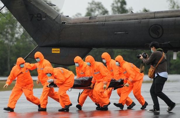 Personal de búsqueda y rescate traslada el cuerpo de una víctima del vuelo QZ8501 de AirAsia en la Base Aérea de Iskandar, en Pangkalan Bun, Indonesia, este domingo. Foto Xinhua
