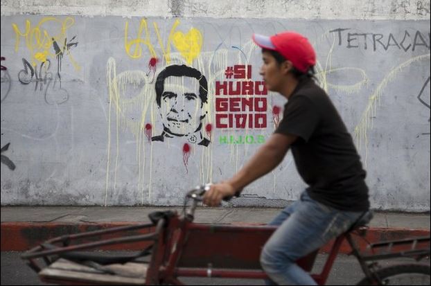 Un hombre en bicicleta pasa junto a un grafitti en la capital guatemaltecea, en el que se lee “Hubo genocidio”, en referencia al juicio que libra el ex dictador guatemalteco Efraín Ríos Montt. Foto Ap